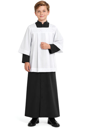 Young altar server wearing a white square neck surplice over a black cassock, showing the pleated front, full sleeves, square yoke, and wide hem.