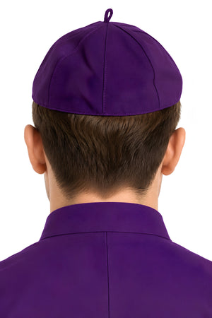 Back view of a person wearing a Roman purple eight-panel clergy zucchetto cap, showing the fitted shape, stitched seams, and small top loop.