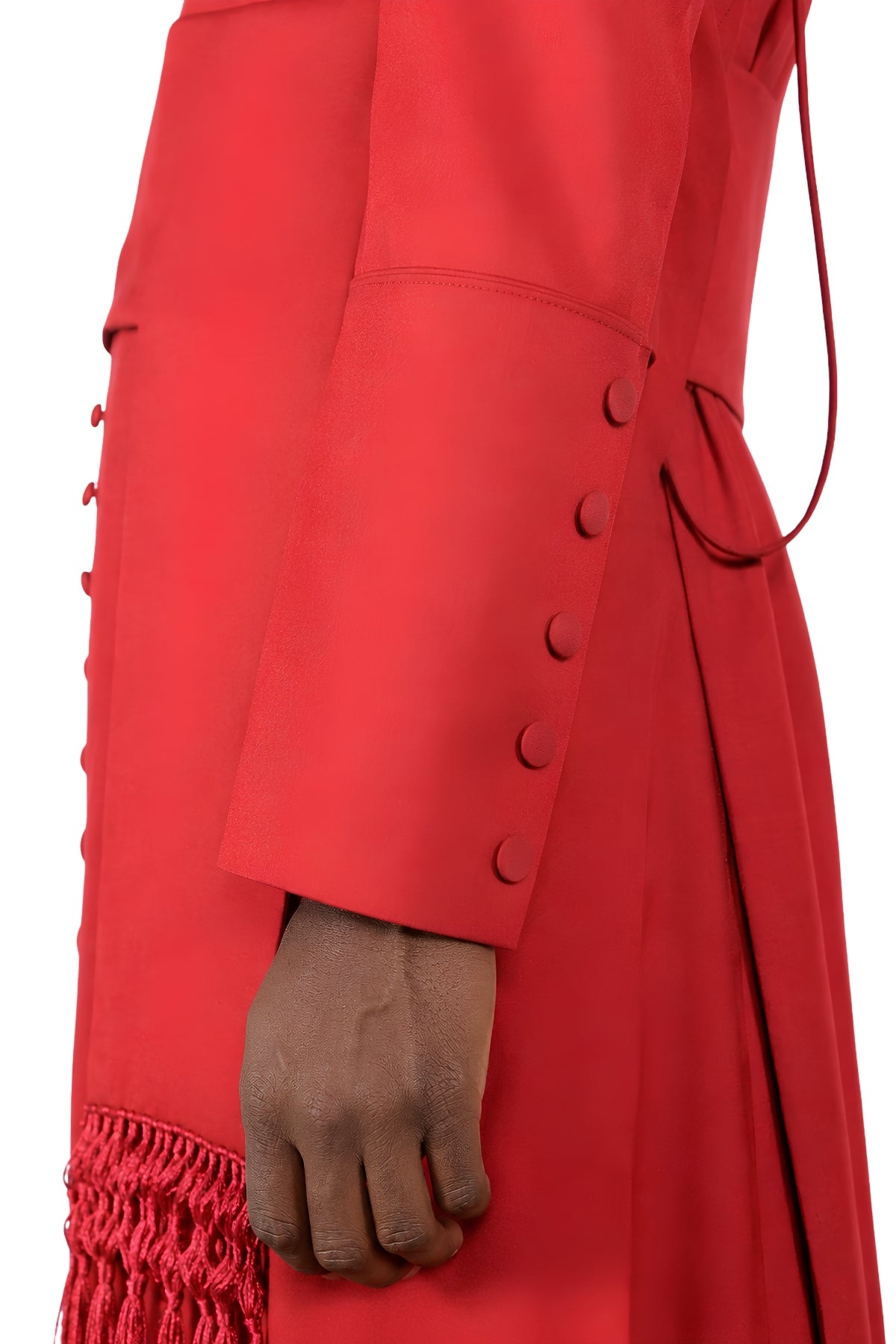 Close-up of cuff buttons and fringed cincture tassel on solid red cassock for men