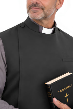 Close-up of the Anglican-style black clerical apron showing the snap closure, shoulder button, clergy collar, and chest pocket