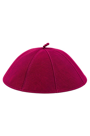 Magenta clergy zucchetto skullcap on a white background, featuring eight stitched fabric panels, a rounded shape, and a matching loop at the crown.
