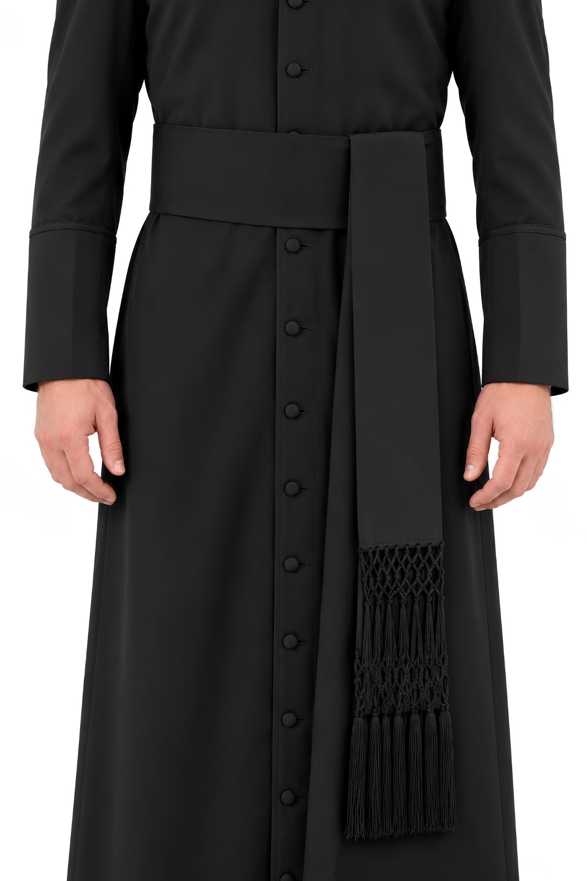 Black Steadfast Devotion band cincture worn over a clergy cassock, featuring a wide waist band and long hand-knotted fringe ends.